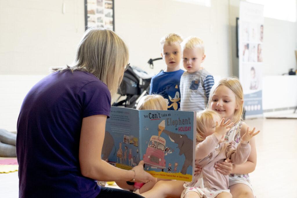 Adult reading to children in a classroom.