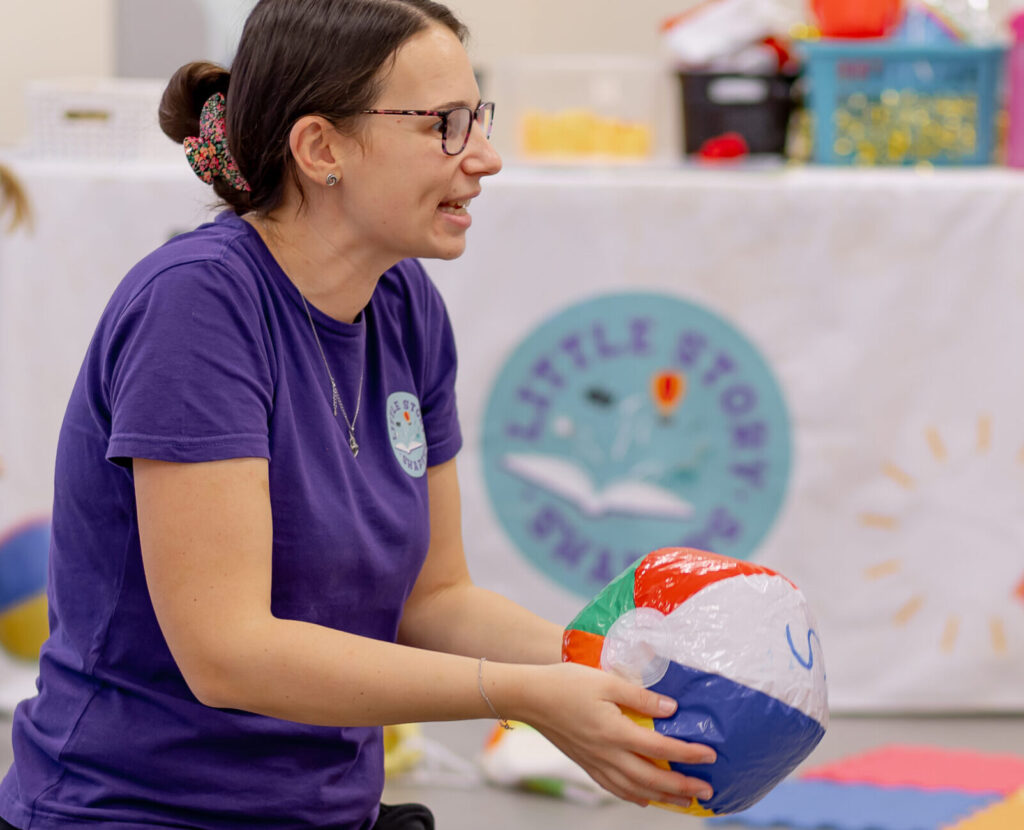 Franchisee running baby and toddler class, throwing beach ball