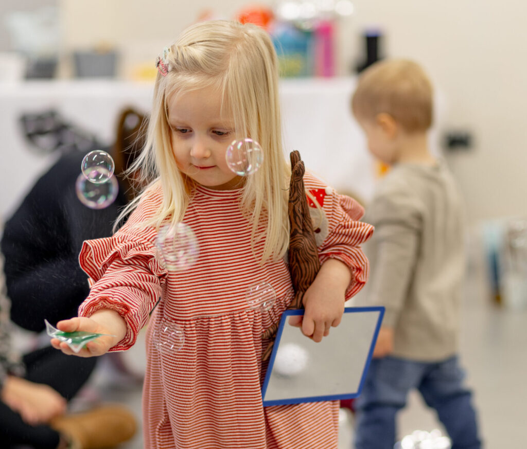 child catching bubbles in storytelling class